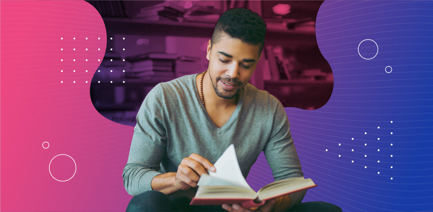 Man looking at a book in a library with pink and purple graphics around him