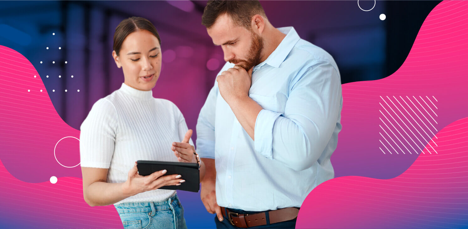 man and woman looking at an ipad and talking